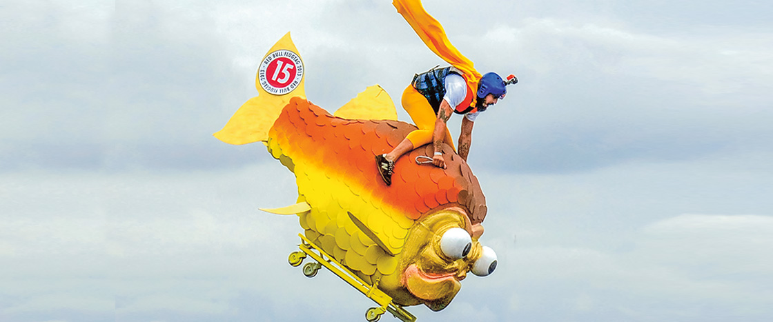 Image of a person riding a fish cart on wheels