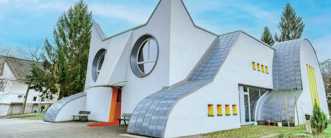A whimsical white building shaped like a cat face with round windows and curved rooflines